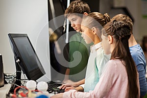 Happy children with computer at robotics school