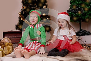 Happy children in costumes opening Christmas gifts