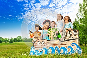 Happy children in costumes standing on ship