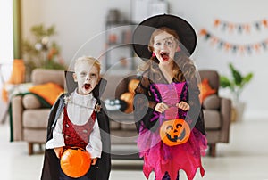 Happy children in costumes of witch and vampire are preparing