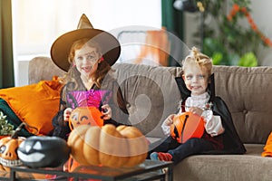 Happy children in costumes of witch and vampire are preparing