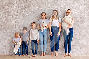 Happy children of different age with puppies standing in line