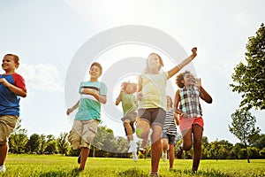 Happy children, diversity and playing with youth in nature for fun, playful day or summer at park. Group of excited kids