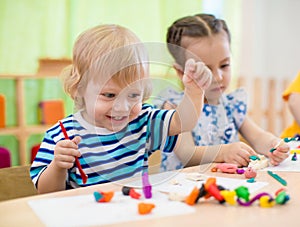 Happy children doing arts and crafts. Kids in kindergarten.