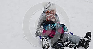 Happy children dragged on a sledge outdoor in winter.