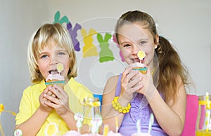 Happy children eating cupcakes in Easter scene