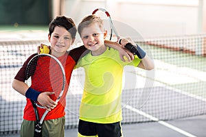 Happy children entertaining on tennis court