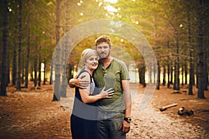 Happy children equals happy parents. a loving couple embracing each other in a hug while standing outside in the woods.