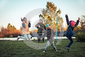 Happy children friends having fun jumping outdoors during summer holidays in countryside symbolizing happy carefree childhoo