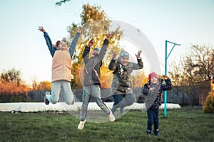 Happy children friends having fun jumping outdoors during summer holidays in countryside symbolizing happy carefree childhood life