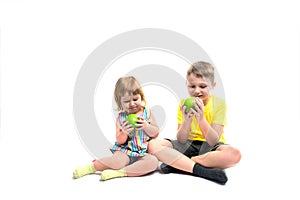 Happy children with fruits. Boy and baby girl eat green apples. isolated on a white background. Healthy food concept, fresh