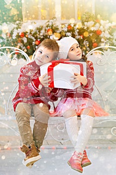 Happy children girl and boy holding gift for Christmas