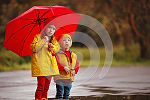 Happy children girl with umbrella on autumn walk