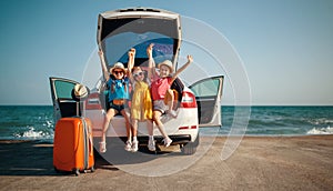 Happy children girls friends sisters on the car ride to summer trip