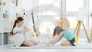 Happy children girls having pillow fight