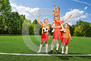 Happy children with golden cup stand in pyramid