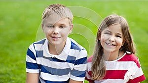 Happy children on green grass in summer park