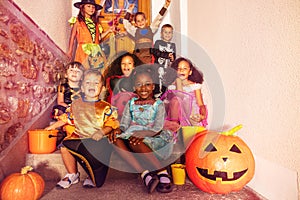 Happy children in Halloween costumes on the stairs