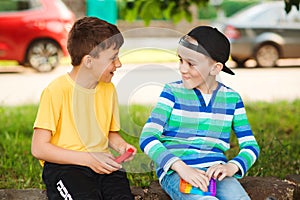 Happy children having fun outdoors. Cute boys playing with trendy pop it toy