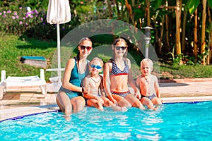 Happy children having fun at the pool during summer vacation