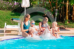 Happy children having fun at the pool during summer vacation