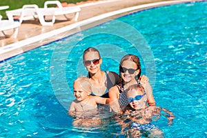 Happy children having fun at the pool during summer vacation