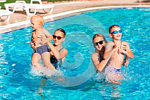 Happy children having fun at the pool during summer vacation