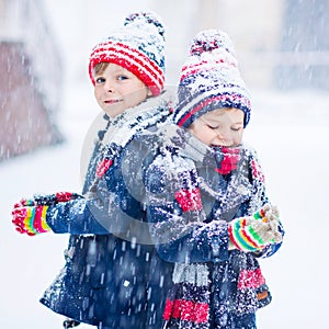 Happy children having fun with snow in winter