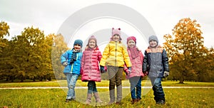 Happy children holding hands in autumn park