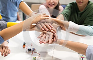 Happy children holding hands at robotics school