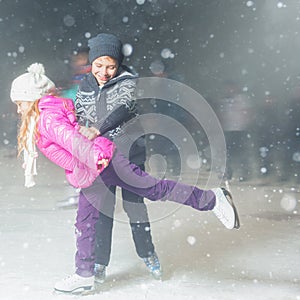 Happy children ice skating at ice rink outdoor, figure skating