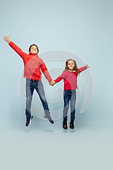 Happy children isolated on blue studio background. Look happy, cheerful, sincere. Copyspace. Childhood, education