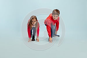 Happy children isolated on blue studio background. Look happy, cheerful, sincere. Copyspace. Childhood, education