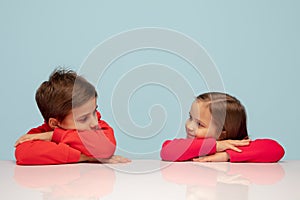 Happy children isolated on blue studio background. Look happy, cheerful, sincere. Copyspace. Childhood, education