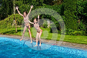 Happy children jump to swimming pool