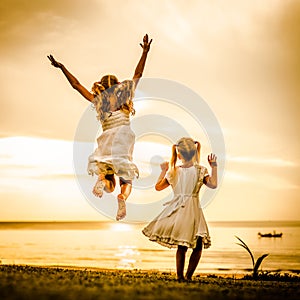 Happy children jumping on the beach