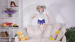Happy children jumping on the bed and having fun. slow motion