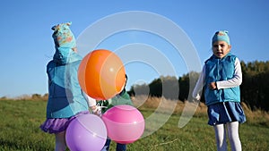 Happy children jumping, laughing and smiling with balloons. Fun outdoors