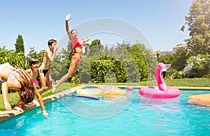 Happy children jumping into the swimming pool