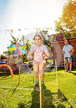 Happy children jumps over strings on playground