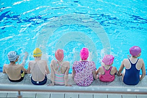 Happy children kids group at swimming pool class learning to swim