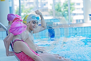 Happy children kids group at swimming pool class learning to swim photo