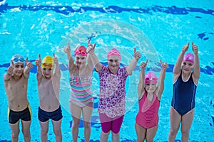 Happy children kids group at swimming pool class learning to swim