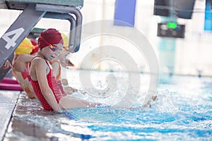 Happy children kids group at swimming pool class learning to swim