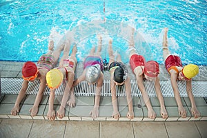 Happy children kids group at swimming pool class learning to swim photo