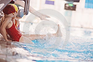 Happy children kids group at swimming pool class learning to swim