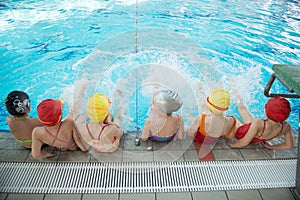 Happy children kids group at swimming pool class learning to swim