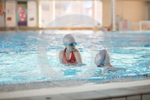 Happy children kids group at swimming pool class learning to swim