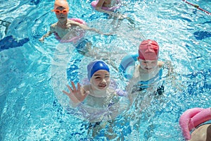 Happy children kids group at swimming pool class learning to swim photo