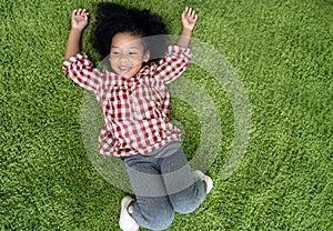 Happy children kids smiling and laying on green carpet floor in living room at home.